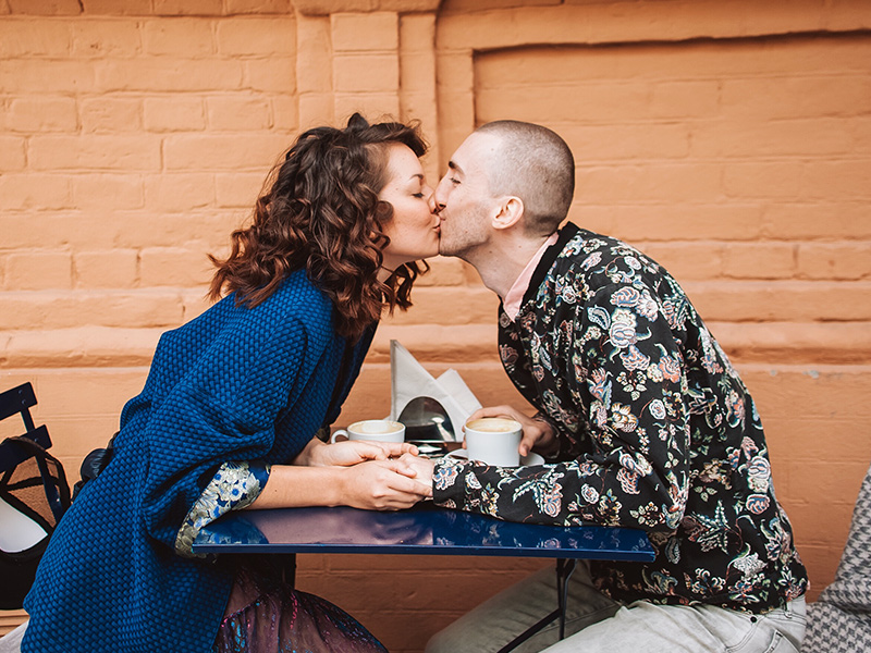 happy couple on sitting at a table outside on a date