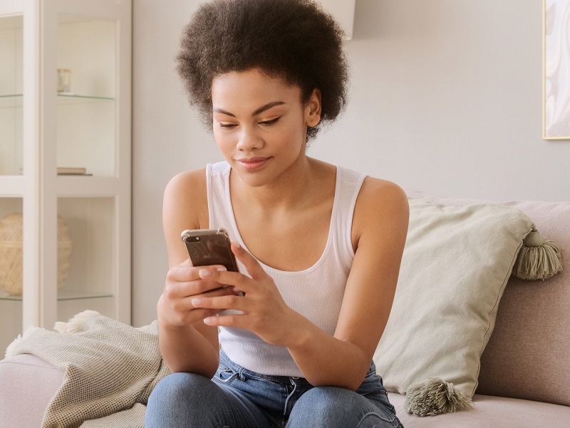 attractive woman sitting on phone texting on her mobile phone