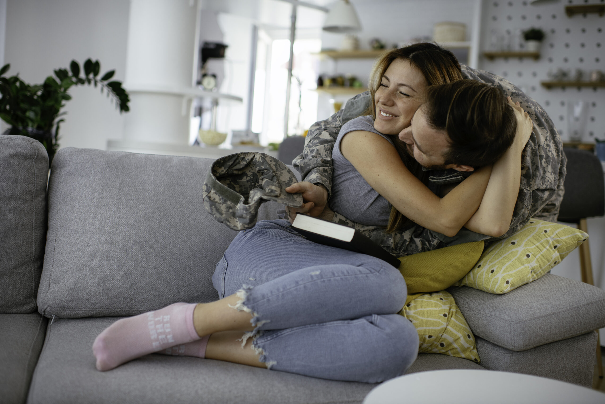 Happy soldier in uniform hugging and embracing his smiling partner after meeting through uniform dating site.