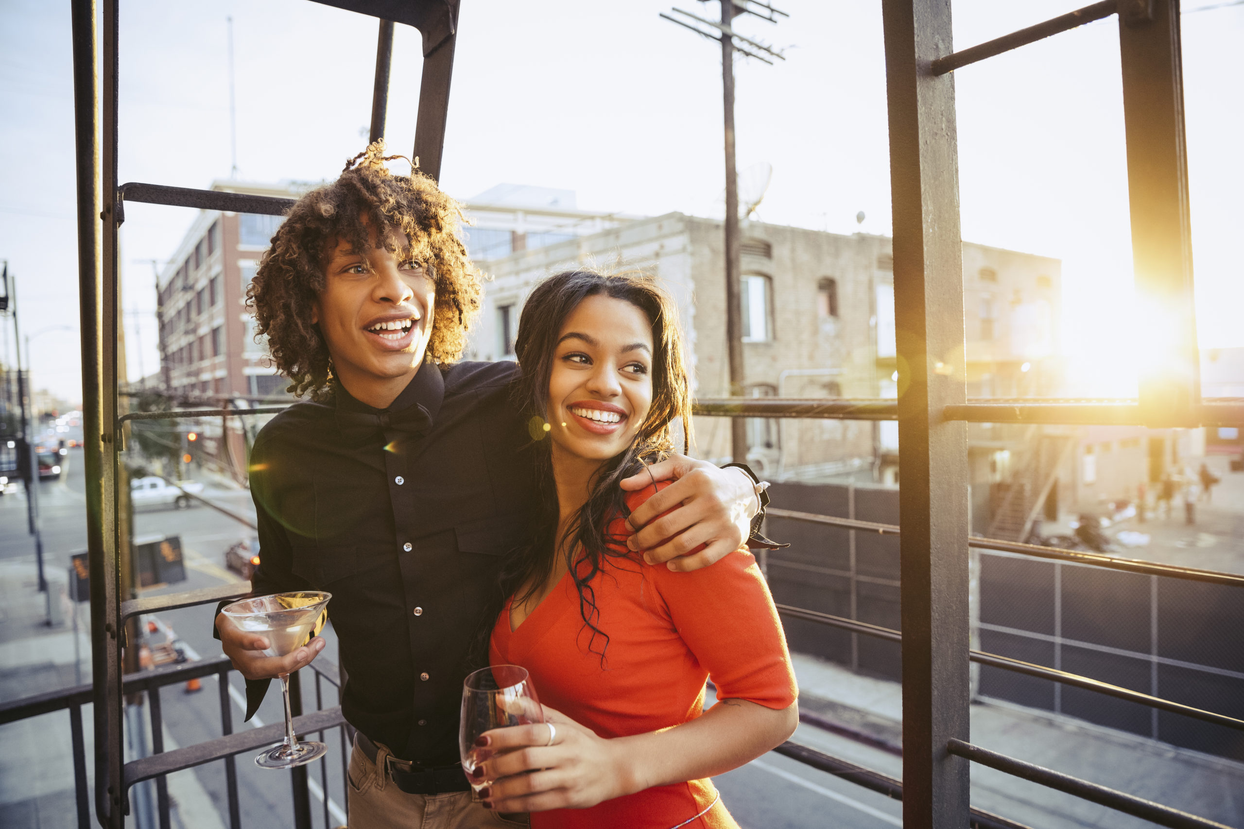 Happy young couple smiling and holding drinks while trying out some cool date ideas.
