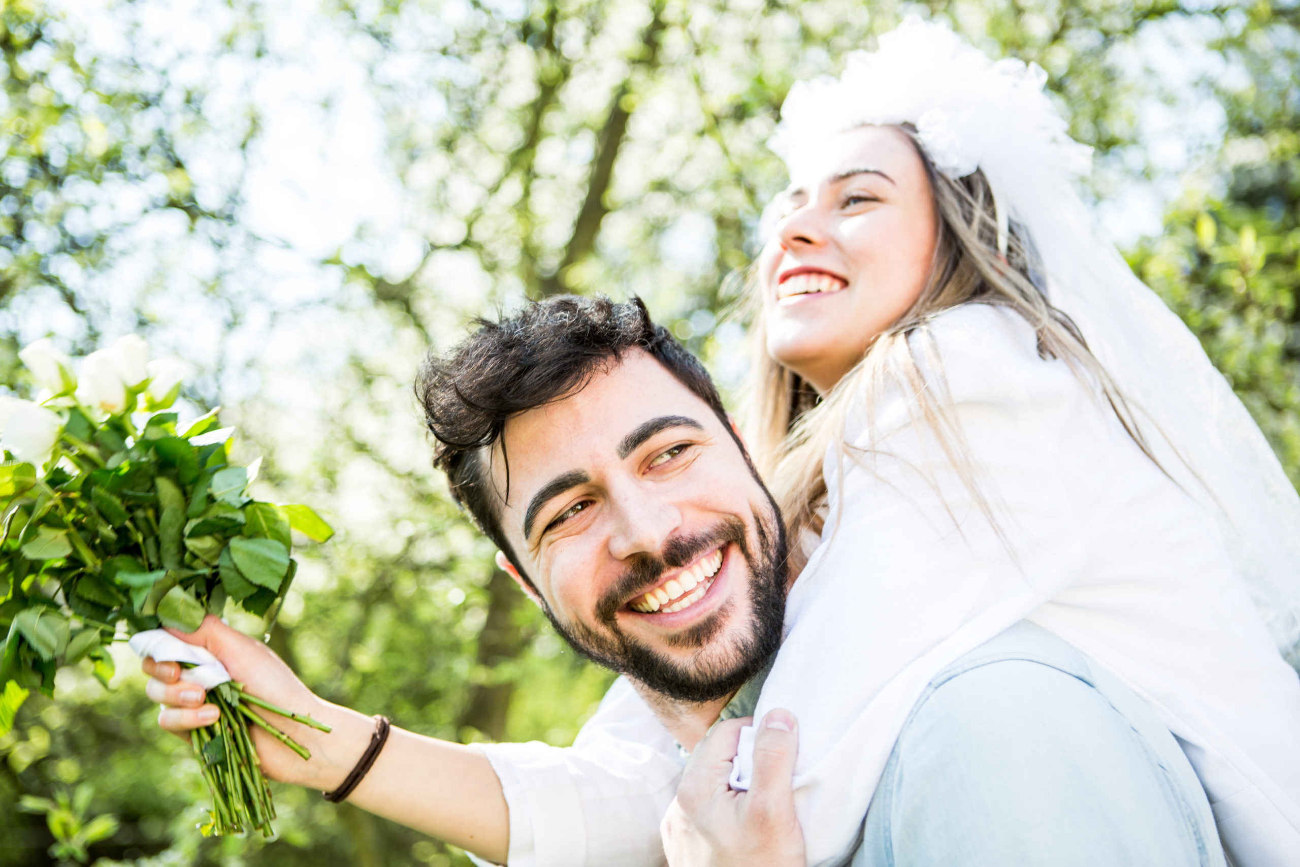 Two happy marriage-minded people smiling and embracing each other on their wedding day.