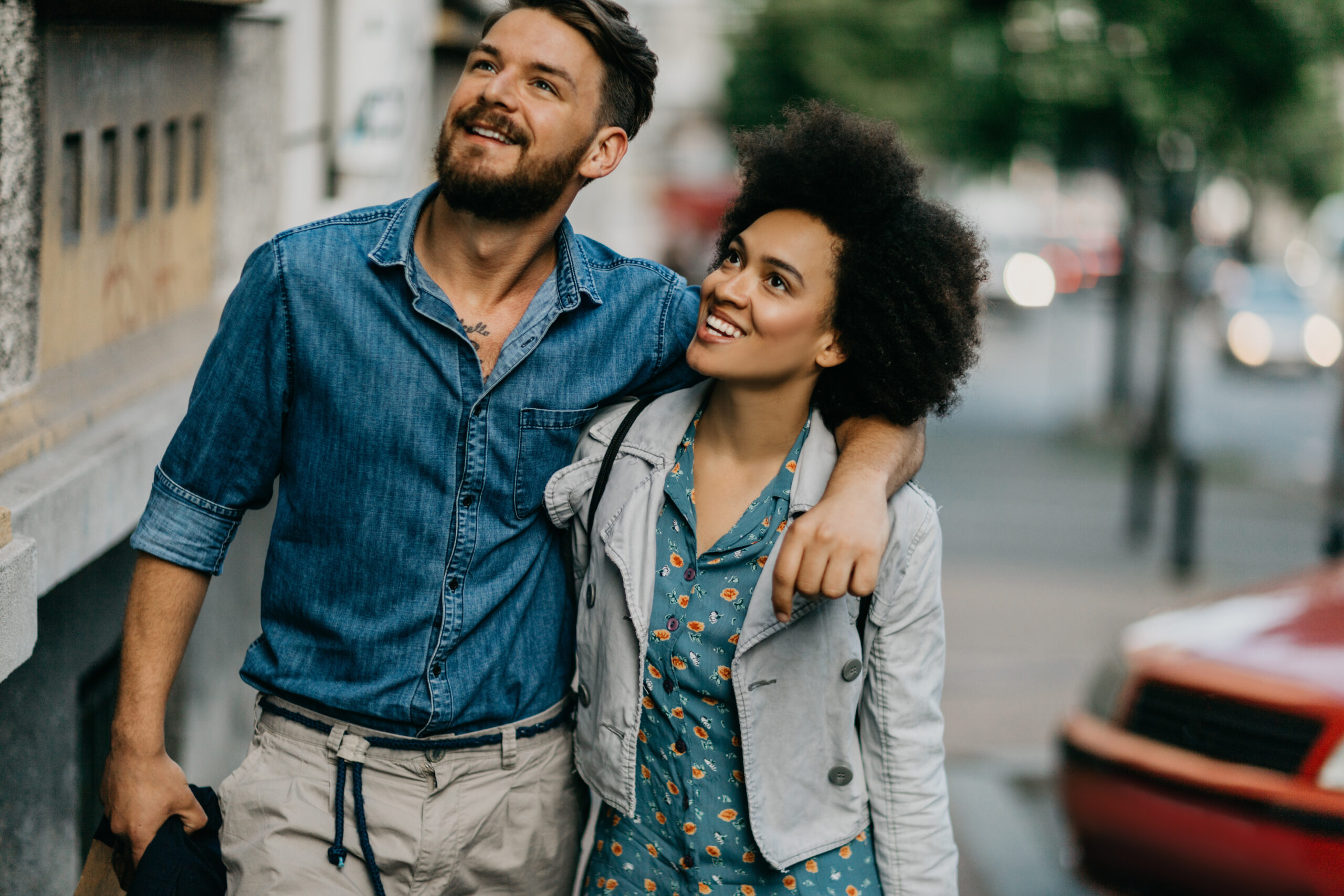 Happy, smiling couple walking down the street arm in arm after meeting and finding love online.